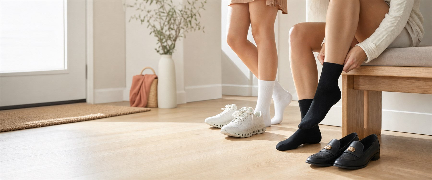 Two women wearing white and black comfort socks in a bright modern entryway